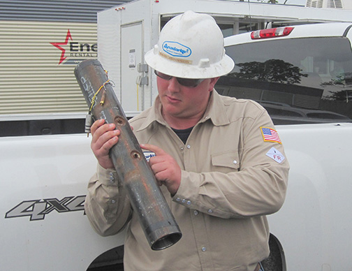 Anadarko production engineer Dave Johnson points to the small holes in a well pipe through which fracked natural gas passes en route to U.S. stoves, furnaces, water heaters and power plants.